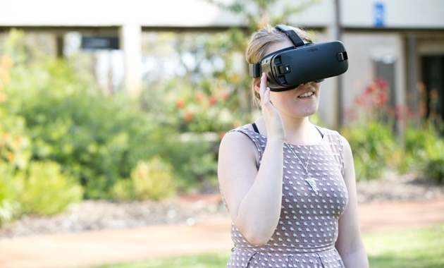 Games Art & Design student wearing VR headset outdoors.